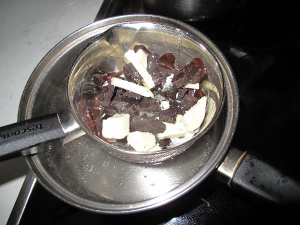 В миске смешайте сливочное масло с черным шоколадом и растопите на водяной бане. 