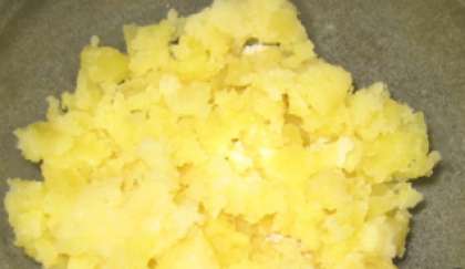 Сначала помойте клубни картофеля. Потом положите их в кастрюлю и варите в кожуре до готовности. Затем остудить картофель и снять с нее «мундир». Потереть на крупной терке готовый картофель.