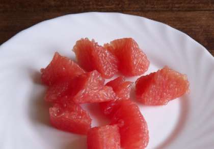 Вымойте грейпфрут. Снимите с него кожуру, удалите белые перегородки. Затем разделите грейпфрут на дольки, аккуратно очистите от кожицы каждую из них.