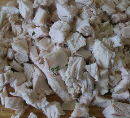 В подсоленной воде отварите вымытое куриное мясо. Готовое филе остудите. Если вы используете куриную грудку или курицу, то сначала нужно отделить мясо от костей. Затем порежьте  на  маленькие кубики.