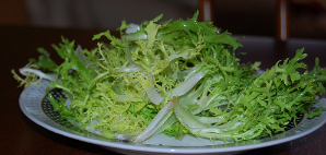 Помойте листья салат фризе. Стряхните лишнюю воду. Затем положите его на центр салатника.