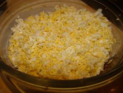 Сварите яйца. Готовые яйца очистите от скорлупы и натрите на терке. Также добавьте майонез и перемешайте в отдельной миске.