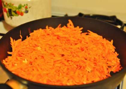 Возьмите морковь. Почистите и промойте. Обсушите  морковь бумажным полотенцем. Потом нужно натереть ее на крупной терке. Поставьте на огонь сковороду. Налейте растительного масла туда. Хорошо разогрейте. Затем нужно высыпать морковь и обжаривать до золотистого цвета, минут 15. Снимите морковь с огня, остудите.
