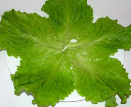 Сполосните листья салата. Обсушите, чтобы не было лишней воды. Затем выложите красиво листья на салатницу, в центр.