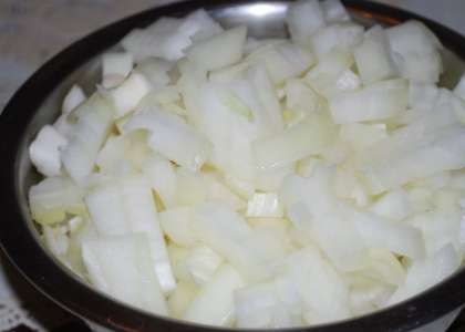 Почистите и вымойте луковицу. Осушите ее. Потом порежьте лук на мелкие квадратики и положите поверх курицы в салатницу. Смажьте майонезом снова.
