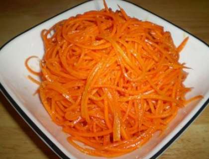 Возьмите корейскую морковку. Лучше, ели она будет с чесночной заправкой и перчиком. Перережьте ее на половину.