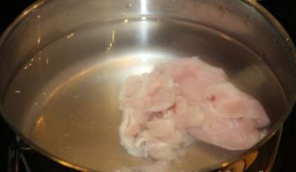 Филе курицы или любую часть курицы с мясом нужно положить в глубокую кастрюлю и залить тремя литрами воды. Довести до кипения, снять образовавшуюся пенку и оставить тихо томиться в течение часа.