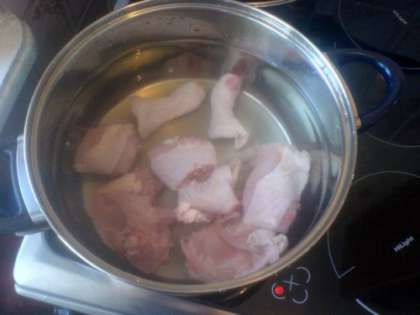 В кастрюлю укладываем нарезанные бедра курицы и заливаем водой. Даем бульону закипеть, затем убавляем, сняв пенку, которая может испортить прозрачность супа. Оставляем томиться на медленном огне не менее 40 минут.
