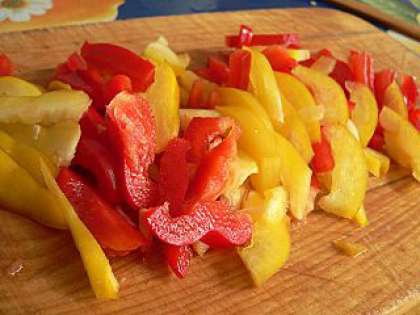 Чистый болгарский перец просушите. Затем  очистите от семян, а также отрежьте плодоножку. Снова сполосните перец, и порежьте его соломкой. Можно брать как красные, так и желтые перчины.
