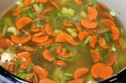 В глубокой кастрюле желательно с толстым дном нужно обжарить лук - порей, затем добавить морковь и болгарский перец. Все тушим в течение 10-15 минут, затем заливаем прожаренные овощи тремя литрами холодной воды и доводим до кипения.  Как только суп закипит, огонь уменьшить и варить в течение 15-20 минут.