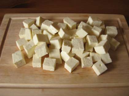 Возьмите сыр «Фета». Это одна из неотъемлемых частей салата. Порежьте его на средние кусочки. Можно также заменить «Фету» брынзой или другим рассольным сыром.