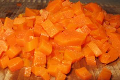 Морковь вымойте. Сварите ее до готовности, не счищая кожуры. Залейте холодной водой. Снимите кожуру. Затем охладите и порежьте небольшими кусочками.