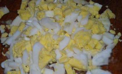 Возьмите яйца. Варите их 5-7 мин. Охладите. Очистите от шкарлупы. Затем порежьте мелкими кусочками.