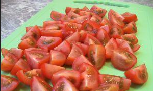 Помойте помидоры. Затем нарежьте их кубиками. Если вы берете помидоры «Черри», то тогда разрежьте их пополам.