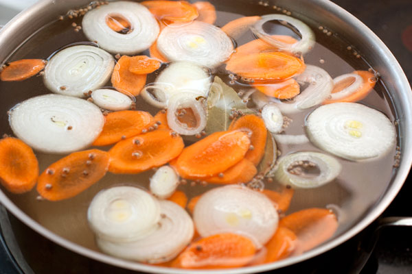 Затем добавьте еще 3-3,5 литра холодной воды, тонко нарезанные лук и морковь. 