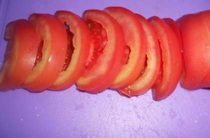 Вымойте помидоры, немного их подсушите. Затем каждый помидор разрежьте пополам. И, после каждую половинку тоже порежьте ломтиками.