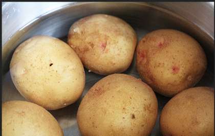 Возьмите картофель (молодой картофель), вымойте его и отварите в кастрюле до готовности. Клубни картофеля при желании можно запечь, так будет еще вкуснее.  Перепелиные яйца тоже сварить, остудить и очистить от кожуры.