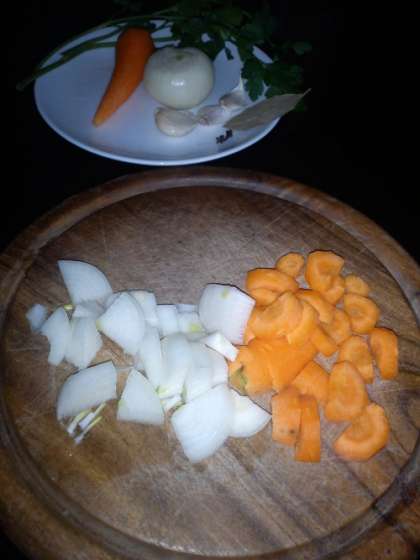 Далее нужно крупно нарезать морковь. Уложить в глубокую емкость для выпекания или в противень свиные кости, добавив к ним репчатый лук, морковь и немного сельдерея. Содержимое емкости нужно хорошо перемешать  и полить все растительным маслом. Обжаривать в духовке в течение 40 минут при температуре 240 градусов. Мешать рекомендуется периодически, подливая немного растительного масла.