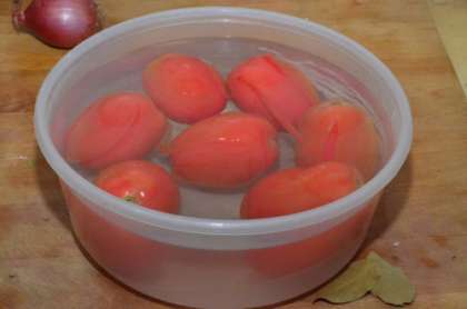 Займёмся самым главным ингредиентом – помидорами. Их нужно хорошо промыть и на верхушке каждого сделать небольшие надрезы крестообразной формы. Затем нужно  сложить их в одну миску и залить кипятком. Оставляем помидоры буквально на несколько минут, тем временем займемся овощами. Что касается помидоров, брать можно томаты любого сорта, вкус соуса от этого сильно не изменится.