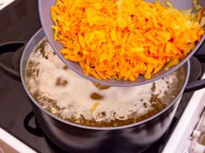 Натираем на терке с крупными отверстиями морковь. Наливаем на сковороду растительное масло и обжариваем лук, как только он позолотится, добавляем к нему морковь и жарим до мягкости.