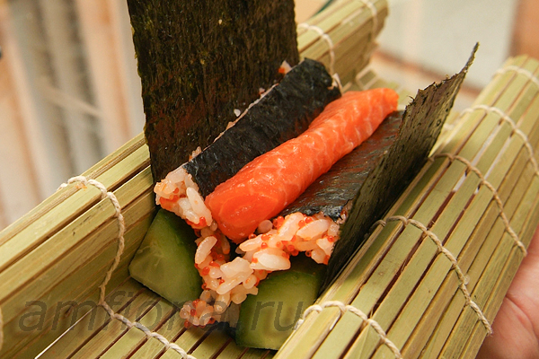 В середину положите начинку. Можно взять любые овощи, японский омлет и т.д. В данном случае использовано небольшое количество лосося для суши.
