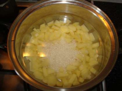 Картошку чистим, режем кубиками помельче и зальем его водой. В это время промоем рис несколько раз холодной водой. Так как рис варится минут пятнадцать, то его можно одновременно закладывать для варки с  картофелем.