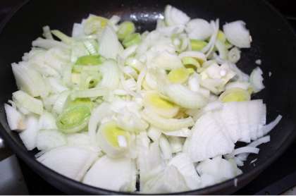 Подготавливаем тем временем овощи. Небольшую луковицу (лучше салатного типа или даже можно взять лук-порей) нарезаем кубиками, нагреваем в сковороде оливковое масло. Добавляем лук и жарим до размягчения, приблизительно пять минут.