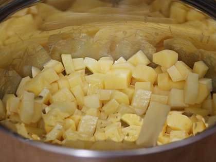 Сначала немного необычно для супа: нарезаем картофель крупными кубиками. В кастрюле топим сливочное масло, кладем картофель и обжариваем не более пяти минут.