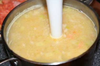 Огонь выключаем и слегка остужаем суп, немного креветок оставляем для украшения, а все остальное содержимое кастрюли измельчаем блендером. Крем суп заново доводим до кипения.Взбиваем яйца и выливаем в кипящий суп, быстро размешиваем. Кладем измельченный чеснок, сыр, вливаем сливки,  и подсаливаем по вкусу. Еще раз все хорошо перемешиваем и сразу снимаем  с огня.