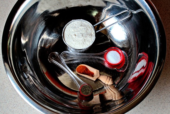 Подогрейте духовку до 200 C. В большой миске смешайте ¼ кружки муки, ½ чайную ложку соли, ¼ чайной ложки черного и ¼ чайной ложки красного перца.