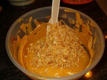 Делаем первый крем. Масло вынимаем из холодильника заранее, чтобы оно стало мягким. Затем взбиваем его с вареной сгущенкой. После того, как крем хорошо взбился, добавляем поджаренные орехи. Хорошо перемешиваем орехи с кремом.