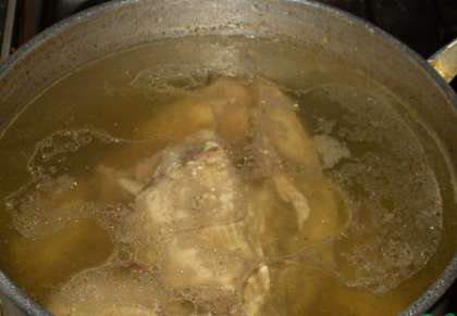 В большую кастрюлю кладем куриное мясо и заливаем готовым кипящим бульоном.
