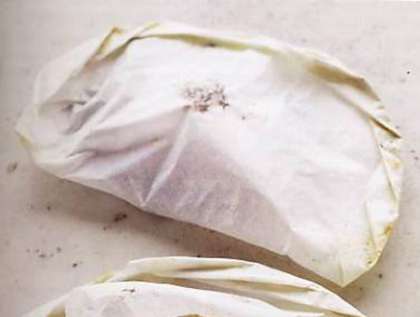 Нарезать пергаментную бумагу для выпечки, середину каждого листа смазать сливочным маслом, положить кусок лосося и завернуть его в бумагу.