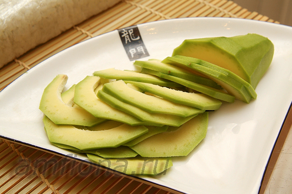 Очистите авокадо (плод должен быть спелым и мягким) от шкурки и нарежьте тонкими пластинками. Это можно сделать ножом или овощечисткой, как вам удобно. 