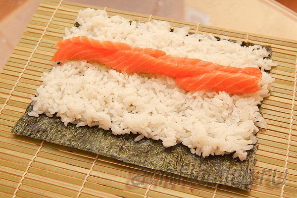 Нанесите немного пасты васаби на рис и выложите несколько ломтиков сёмги для суши.