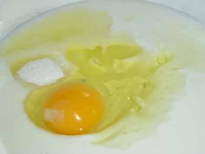 В кефир добавляем одно яйцо, сахар, соль и растительное масло, хорошенько перемешиваем.
