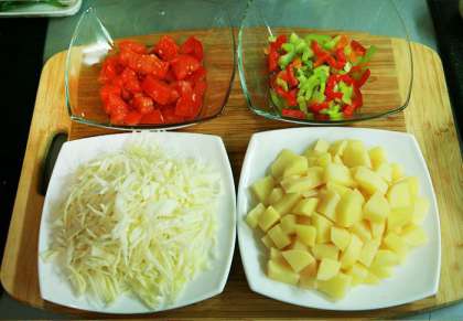 Нарезаем кубиками картошку и тонко шинкуем капусту. Не много. Одной небольшой пиалы будет достаточно.  Также нарезаем мелкими ломтиками болгарский сладкий перец и помидоры.