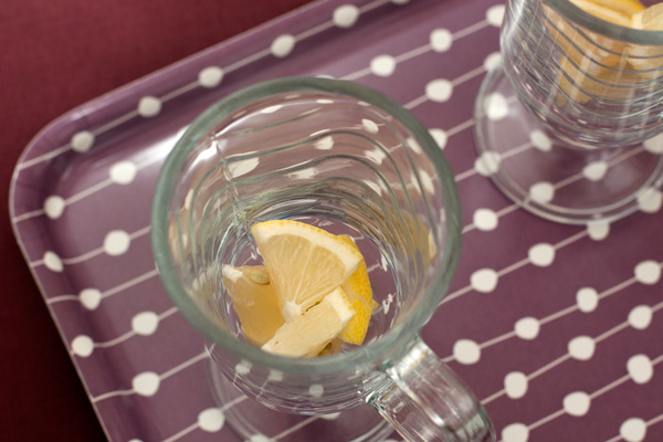 Оставшийся лимон нарежьте кружочками, каждый из которых разрежьте на 8 частей и положите в чашки или бокалы для горячих напитков.