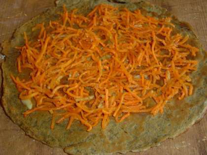 На блинчики выкладываем морковь по-корейски и распределяем по всей поверхности,