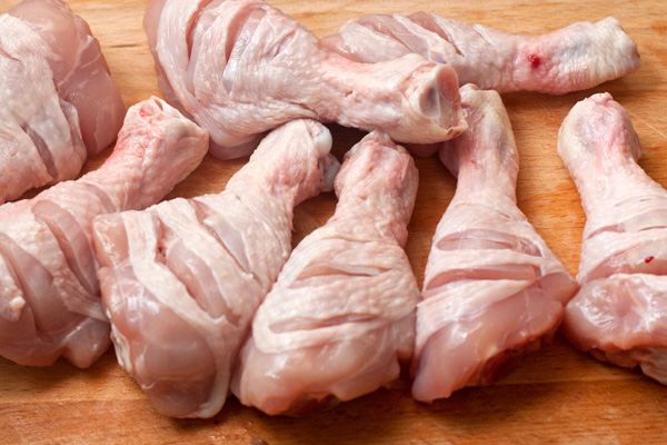 Голени вымойте холодной водой, обсушите. На каждой голени острым ножом сделайте по три надреза с двух сторон до кости. Так маринад легче проникнет в мясо и курица быстрее приготовится.
