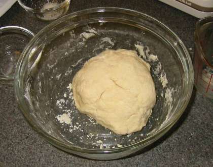 Аккуратно вливайте молоко в смесь. Руками продавливайте тесто и сделайте из него шар.    Далее раскатайте тесто тонким слоем. Можно доставать формы для печенья и приступать к выпечке.