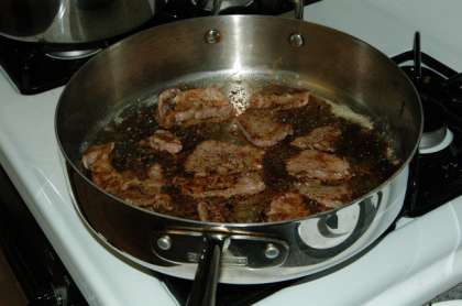 После того как масло перестанет пениться положите говядину на горячую сковороду. Поджаривайте мясо с обоих сторон до слегка коричневого цвета.