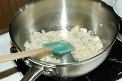 Растопите две столовые ложки жира в глубокой сковороде и добавьте лук.