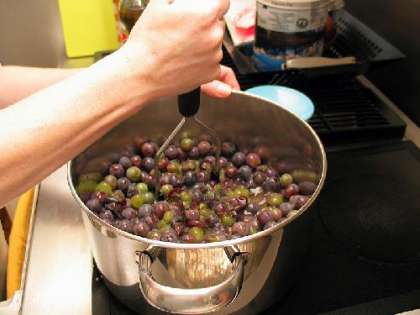 Добавьте немного воды и раздавите виноград.
