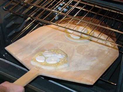 Слегка помажьте тесто оливковым маслом. И поместите кружки выпекаться в духовку.