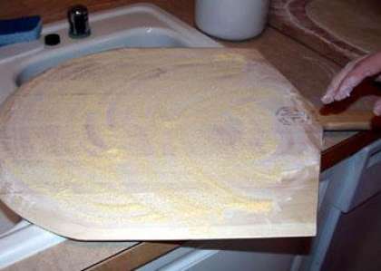 Перекладываем тесто на лопатку посыпанную мукой.