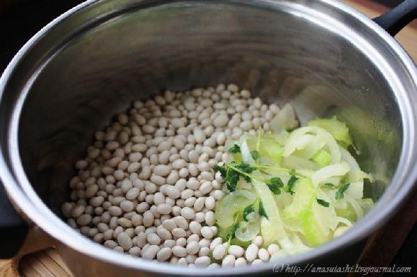 Выкладываем зажарку в кастрюлю, добавляем белую фасоль и заливаем овощным бульоном. Доводим до кипения, снимаем крышку и тушим до готовности.
