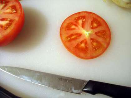 Вырезаем пару ломтиков помидора.