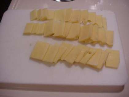 Режем сыр на небольшие ломтики.