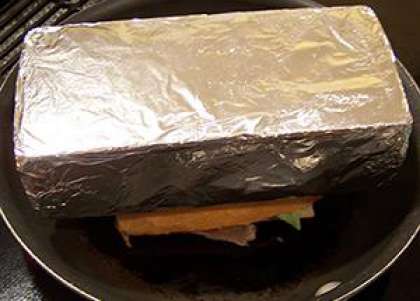Положите кирпич на бутерброд пока он слегка поджарится.